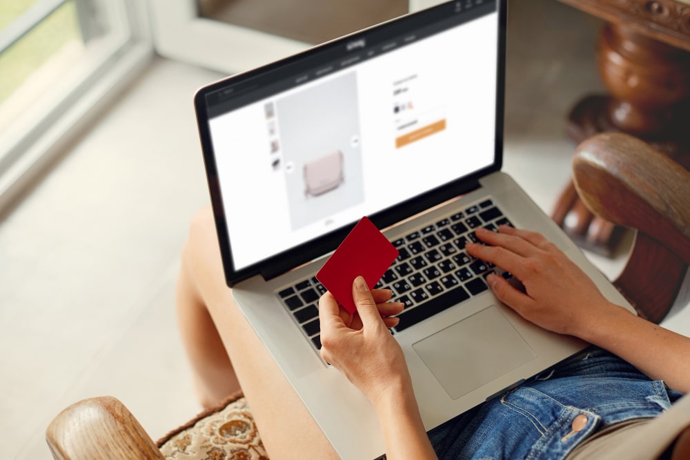 woman is holding credit card using laptop computer concept shopping online technology working from home min